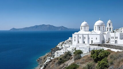 Whitewashed churches on a hillside overlooking the sea.