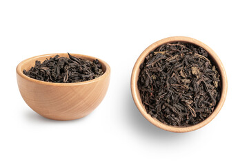 Black dry tea  leaves in wooden bowl isolated on white background.