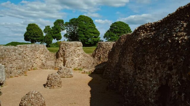 Ruined ramparts, grassy terraces and scattered stone foundations atop the windswept hill, Old Sarum, Salisbury, Wiltshire, England, UK