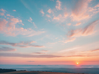 Fototapeta premium A panoramic landscape photograph capturing a beautiful sunrise or sunset sky with soft pastel clouds in hues of blue, pink, and orange.