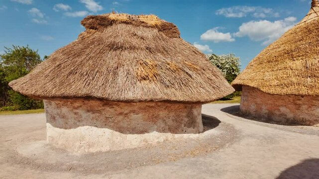 Reconstructed thatched roundhouses and timber structures evoking Neolithic village at Stonehenge, Salisbury, Wiltshire, England, UK