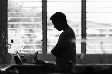 Sad young man alone at home feeling depressed lonely struggling with his mental health 