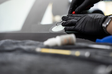 Precision windshield crack repair in progress with specialized tools. Professional windshield chip...
