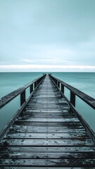 Fototapeta premium Symmetrical wide-angle shot of weathered wooden pier extending to ocean horizon