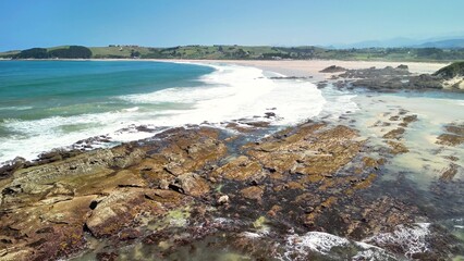A beautiful scenic coastal view showcasing rolling waves crashing against a rocky shoreline