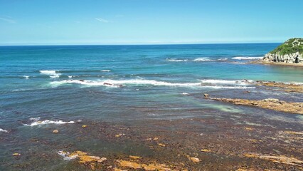 Enjoy a serene coastal view with clear waters and a rocky shoreline in a beautiful setting