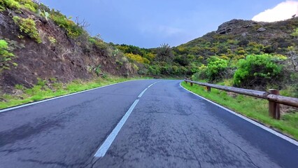 A Scenic Winding Road That Winds Through Beautiful Lush Green Hills Under a Bright Blue Sky