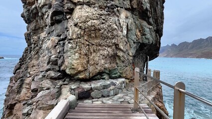 Enjoying a scenic coastal pathway along a rocky cliffside with a stunning ocean view