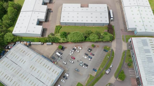 Aerial view drone flight above business park warehouse district factory units data centre quantum computing on a sunny day in the UK logistics and transport of goods economics. 