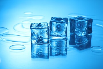 Cubes of clear ice on light blue background