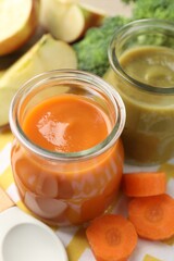 Baby food. Tasty puree in glass jars and ingredients on table, closeup