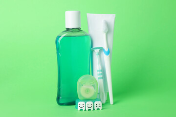 Different oral care products and teeth figures on green background
