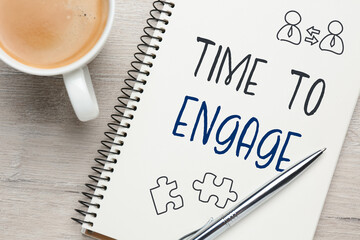 Time to engage. Words and drawings in notebook and coffee on wooden table, top view
