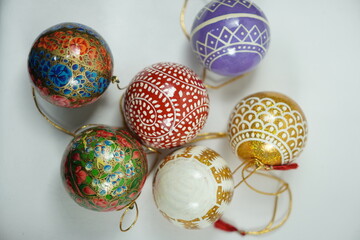 Hand-painted papier-mâché Christmas goodies by Kaar Kash, featuring stars, bells, trees, and more—crafted for hanging on Christmas trees and adding artisanal charm to festive décor.

