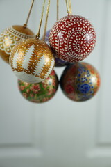 Hand-painted papier-mâché Christmas balls designed for hanging on Christmas trees, combining traditional craftsmanship with festive charm for seasonal decoration.

