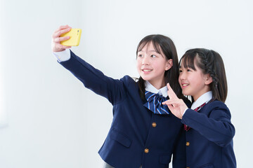 スマートフォンで自撮りをする女子学生