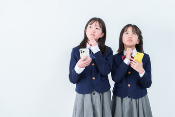 スマートフォンを持ちながら考え事をする女子学生