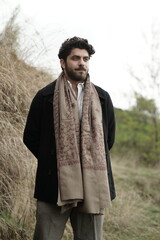 A Kashmiri model dressed in a traditional shawl and vintage-style pheran, posing for a Kaar Kash shoot that highlights timeless craftsmanship and the cultural soul of Kashmir.

