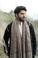 A Kashmiri model dressed in a traditional shawl and vintage-style pheran, posing for a Kaar Kash shoot that highlights timeless craftsmanship and the cultural soul of Kashmir.

