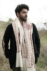 A Kashmiri model dressed in a traditional shawl and vintage-style pheran, posing for a Kaar Kash shoot that highlights timeless craftsmanship and the cultural soul of Kashmir.

