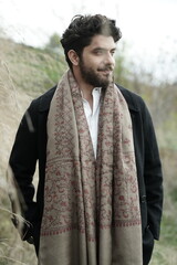 A Kashmiri model dressed in a traditional shawl and vintage-style pheran, posing for a Kaar Kash shoot that highlights timeless craftsmanship and the cultural soul of Kashmir.

