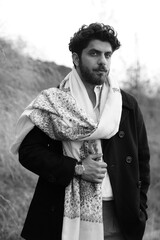 A Kashmiri model dressed in a traditional shawl and vintage-style pheran, posing for a Kaar Kash shoot that highlights timeless craftsmanship and the cultural soul of Kashmir.

