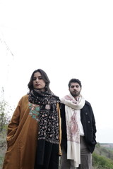 A couple posing in traditional Kashmiri attire, adorned in handwoven shawls and embroidered pherans, showcasing the rich heritage and artistry of Kaar Kash in a styled fashion shoot.

