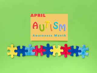 Autism Awareness Month design with colorful puzzle pieces and text 