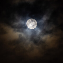 Full moon in the night sky with clouds. Abstract nature background.