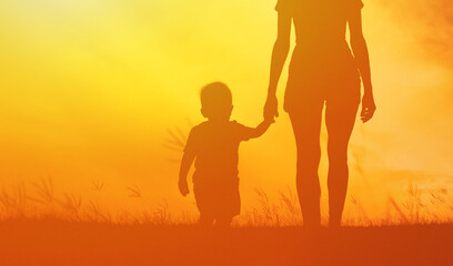 Mother and child walking into the sunset 