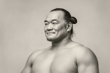 Fototapeta premium japanese sumo wrestler deep in thought positioned on right side of frame showing gentle smile