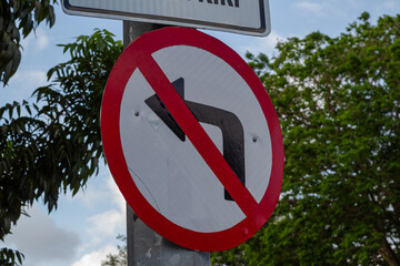 No Left Turn Traffic Sign Against Green Trees