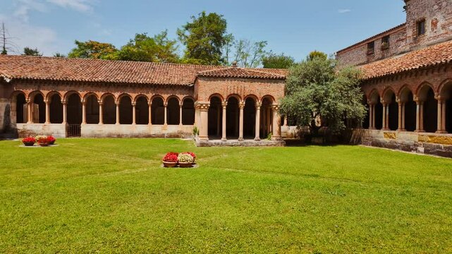 Cloister of Basilica di San Zeno Maggiore reveals its serene square garden framed by arcaded walkways and slender columns, Verona, Veneto, Italy