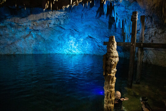 CENOTES Impresionantes estalactitas y columnas naturales reflejadas en el agua cristalina de un cenote subterr&aacute;neo
