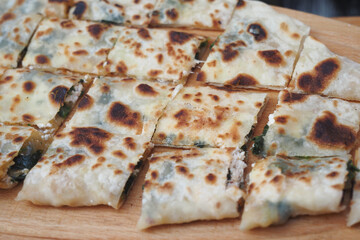 Deliciously cooked flatbread with filling on wooden board