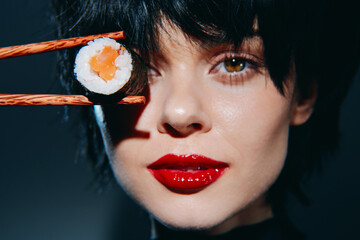 A close-up portrait of a woman holding sushi with chopsticks, showcasing vibrant colors and bold emotions, perfect for culinary-themed projects.