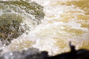 A serene river flows powerfully through a lush, waters cascading down a mountain slope,Red flood water flows from the mountains, Nature of forests and red streams formed by the previous heavy rain