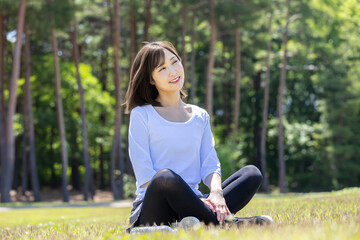 緑地で深呼吸する女性