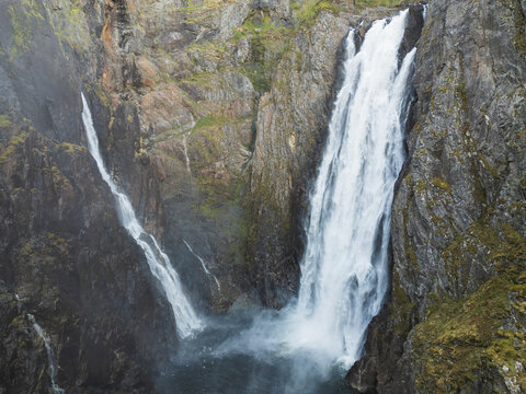 A breathtaking drone view of the powerful Voringsfossen waterfall in Norway, an aerial shot of the majestic rocky canyon and rushing water. - Powered by Adobe