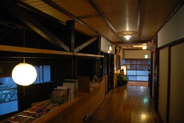 古民家風旅館の木製廊下と照明の温かみ