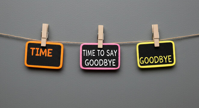 Three signs hanging from a string with clothespins displaying the words time to say goodbye business ,technology ,selling ,purchasing ,agreement ,$