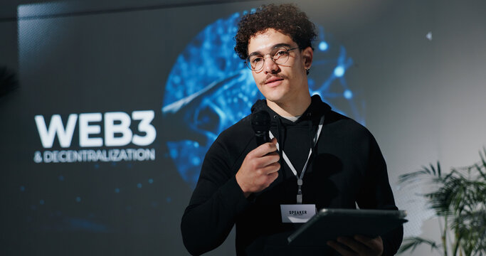 Man, tablet and mic for presentation with web3, decentralization and blockchain by screen for future. Person, speaker and touchscreen with app, innovation and discussion on stage at tech convention