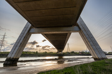 Obraz premium View from beneath the Flintshire Bridge, showcasing its sturdy concrete structure over River Dee at sunrise