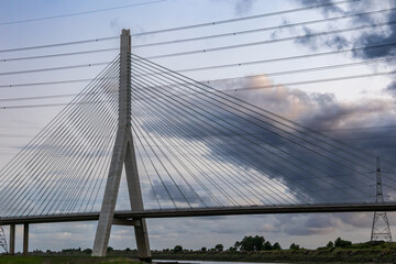 Flintshire Bridge's main pylon and cables are silhouetted against a cloudy sunrise