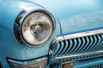 Vintage Blue Car Headlight and Grille Close-Up