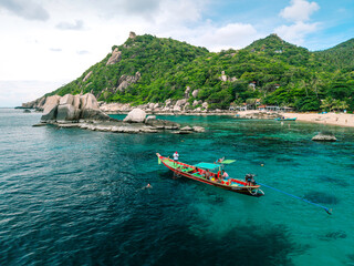Vibrant Thai Longtail Boat in Turquoise Waters by Tropical Beach and Lush Mountains