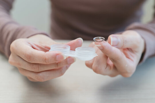 Close-up shot of woman putting contact lens in her eyes