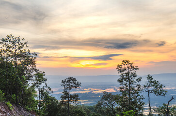Beautiful view of the sunrise, light through the clouds on the mountain top, reflecting on the water in the rice fields, rural area of ​​Phayao Province, Northern Thailand.