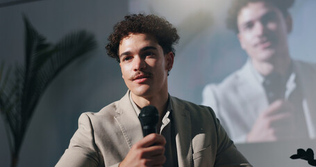 Seminar, training and man with mic, speech or motivational speaker for session, serious and...