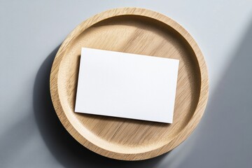 Blank card on wood plate, gray background, light